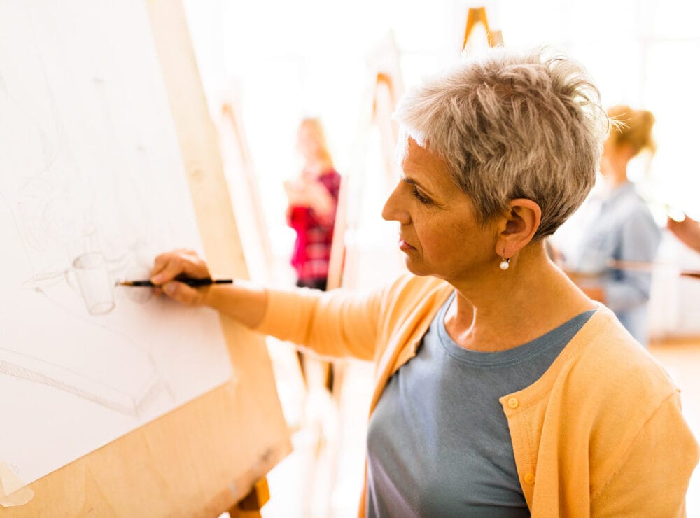 woman artist with pencil drawing at art school